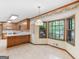 Bright kitchen with a breakfast bar, wooden cabinets, and a bay window overlooking the backyard at 25 Ridgeview Dr, Jonesboro, GA 30236