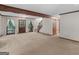Spacious living room featuring a wooden accent beam, staircase and access to the backyard at 25 Ridgeview Dr, Jonesboro, GA 30236