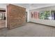 Bright sunroom features brick accent wall, ceiling fan and a wall of windows overlooking the yard at 25 Ridgeview Dr, Jonesboro, GA 30236