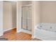 Bright bathroom featuring a glass shower and a luxurious white jacuzzi tub at 362 Interlake Pass, Mcdonough, GA 30252