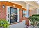 Close-up of the front door featuring sidelights and a covered porch with brick pillars at 362 Interlake Pass, Mcdonough, GA 30252