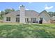 Large backyard with a patio seating area and lush green lawn perfect for outdoor entertaining and relaxation at 155 Westminister Village Blvd, Sharpsburg, GA 30277
