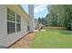 Well-maintained backyard features a patio, grill, lush lawn, and mature trees providing a tranquil outdoor space at 155 Westminister Village Blvd, Sharpsburg, GA 30277