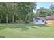 The backyard includes a storage shed, well-maintained lawn, and mature trees offering a private and serene outdoor space at 155 Westminister Village Blvd, Sharpsburg, GA 30277