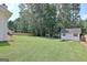 Expansive backyard with lush green grass, a storage shed, a privacy fence, and plenty of shade trees at 155 Westminister Village Blvd, Sharpsburg, GA 30277