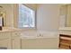 Bright bathroom featuring a soaking tub, vanity with makeup station, tiled flooring and window at 155 Westminister Village Blvd, Sharpsburg, GA 30277
