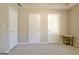 Bedroom featuring neutral carpet and walls with three doors and a small table at 155 Westminister Village Blvd, Sharpsburg, GA 30277