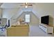 Finished bonus room with neutral carpet, TV, ceiling fan, and comfortable seating at 155 Westminister Village Blvd, Sharpsburg, GA 30277