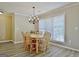 Traditional dining room featuring a wood table, chandelier, and a large window for natural light at 155 Westminister Village Blvd, Sharpsburg, GA 30277