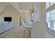 The open concept dining area showcases a modern chandelier, hardwood floors, and an open layout at 155 Westminister Village Blvd, Sharpsburg, GA 30277