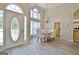 Open-concept dining room features an elegant chandelier and a view of the front door and entryway at 155 Westminister Village Blvd, Sharpsburg, GA 30277
