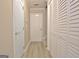 Hallway with white doors, including closet space, and light-colored flooring at 155 Westminister Village Blvd, Sharpsburg, GA 30277