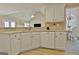 Bright kitchen features white cabinets, a dishwasher, and a breakfast bar area, connecting to an adjacent dining space at 155 Westminister Village Blvd, Sharpsburg, GA 30277