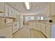 Open-concept kitchen with light wood floors, white cabinets and appliances, and breakfast bar at 155 Westminister Village Blvd, Sharpsburg, GA 30277