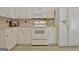 Well-lit kitchen showcasing white appliances, cabinetry, and countertops with neutral tile backsplash at 155 Westminister Village Blvd, Sharpsburg, GA 30277