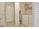 Laundry room showing washer, dryer, storage shelves, and bi-fold closet doors at 155 Westminister Village Blvd, Sharpsburg, GA 30277