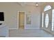 Spacious living room with hardwood floors, front door with windows and view of a hallway at 155 Westminister Village Blvd, Sharpsburg, GA 30277