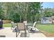 Outdoor patio with table and chairs surrounded by lush greenery and trees at 155 Westminister Village Blvd, Sharpsburg, GA 30277