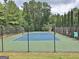 Fenced community tennis court with well-maintained green and blue playing surface at 155 Westminister Village Blvd, Sharpsburg, GA 30277