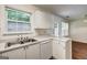 Bright kitchen with stainless steel sink, white cabinets, and views of the backyard at 134 Watercress Ct, Stockbridge, GA 30281
