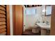 Basement bathroom showcasing a sink, toilet, and wooden-slatted door, offering convenience and privacy at 1527 Patricia Dr, Morrow, GA 30260