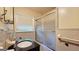 Bathroom with window, sliding shower doors, vanity with dark cabinet, tile wainscoting and patterned floor at 1527 Patricia Dr, Morrow, GA 30260
