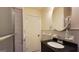 Bathroom with tiled shower and tub combo, round mirror and vanity with black countertop at 1527 Patricia Dr, Morrow, GA 30260