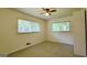 Bedroom with carpet, ceiling fan, and windows overlooking backyard and front yard at 1527 Patricia Dr, Morrow, GA 30260