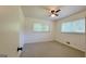 Bedroom with carpet, ceiling fan, and two windows overlooking front yard at 1527 Patricia Dr, Morrow, GA 30260