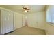 Cozy bedroom features a ceiling fan, carpet, closet and two doors at 1527 Patricia Dr, Morrow, GA 30260