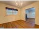 Bright dining room with hardwood floors and a chandelier, with a glimpse into the living area at 6111 Old Monticello Se St, Covington, GA 30014