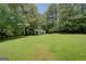 Exterior of the house, showing its setting on a large grassy lot with mature trees at 6111 Old Monticello Se St, Covington, GA 30014