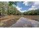 Scenic view of a calm pond framed by mature trees, a tranquil natural setting at 6111 Old Monticello Se St, Covington, GA 30014