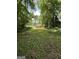 Spacious backyard framed by mature trees with a glimpse of a structure in the distance at 1597 Joseph E Boone Nw Blvd, Atlanta, GA 30314