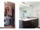 Bright bathroom featuring a double sink vanity, granite counters, and a walk-in closet with ample storage at 11096 Cornerstone Way, Hampton, GA 30228