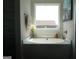 Tranquil bathtub area with a large window providing natural light and a view at 11096 Cornerstone Way, Hampton, GA 30228