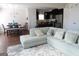 Bright open-concept living space featuring hardwood floors, light gray sofa, dining table, and flows into a modern kitchen at 11096 Cornerstone Way, Hampton, GA 30228