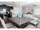 Spacious open-concept living area with dark cabinets, stainless steel appliances, dining table, and comfortable seating at 11096 Cornerstone Way, Hampton, GA 30228