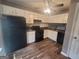 Classic kitchen featuring white cabinets, dark countertops and black appliances at 2052 Charter Ln, Lithonia, GA 30058