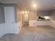 Open-concept living room with neutral carpet, white wainscoting and entry to the kitchen at 2052 Charter Ln, Lithonia, GA 30058