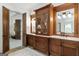 Vanity area with wood cabinetry, marble countertop and a framed mirror for added charm at 4874 Kettle River Pt, Suwanee, GA 30024