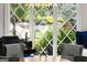 Close-up of dining area with a view of a lush garden through a decorative diamond-patterned window at 4874 Kettle River Pt, Suwanee, GA 30024