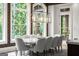 Bright dining room features a long table with seating for ten and large picture windows at 4874 Kettle River Pt, Suwanee, GA 30024