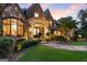 Stunning stone and brick home featuring a lush green lawn and elegant landscaping at 4874 Kettle River Pt, Suwanee, GA 30024