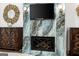 Elegant fireplace with detailed tilework, decorative sconces, a mounted television and custom woodwork at 4874 Kettle River Pt, Suwanee, GA 30024