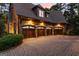 Four-car garage with custom wood doors and a paved driveway, providing ample parking space at 4874 Kettle River Pt, Suwanee, GA 30024