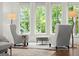 Bright sitting room with large windows providing abundant natural light and comfortable chairs at 4874 Kettle River Pt, Suwanee, GA 30024
