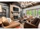 Elegant living room featuring a stone fireplace, coffered ceiling, and comfortable leather furniture at 4874 Kettle River Pt, Suwanee, GA 30024