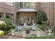 Cozy patio with a stone fire pit, surrounded by Adirondack chairs and lush landscaping at 4874 Kettle River Pt, Suwanee, GA 30024