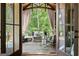 Inviting outdoor patio with comfortable seating, curtains, and a beautiful view of the surrounding trees at 4874 Kettle River Pt, Suwanee, GA 30024